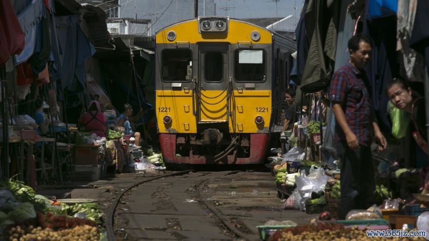 MAEKLONG, THAILAND - AUGUST 29: The train arrives  at the train market in Maeklong, Thailand on August 29, 2013.  The famous market train runs along the Maeklong Railway which is a railway that travels for nearly 67 kilometres between Wongwian Yai, outside of Bangkok to Samut Songkhram in Central Thailand. The market is located around the train track which means that whenever a train approaches, the shop fronts are moved back from the rails, then replaced moments after the train has passed. (Photo by Paula Bronstein/Getty Images)



